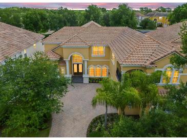 Two-story house with tile roof, large windows, and a three-car garage at 334 Chadwick Dr, Davenport, FL 33837