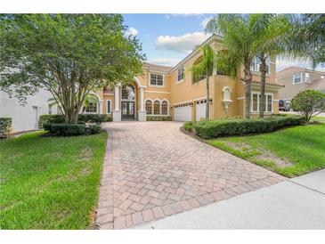 Elegant two-story home featuring a paver driveway, manicured landscaping, and a two-car garage at 334 Chadwick Dr, Davenport, FL 33837