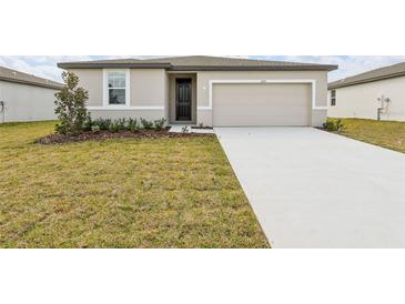 Charming single-story home featuring a well-maintained lawn, neutral color scheme, and attached garage at 1709 Forest Run Ln, Auburndale, FL 33823