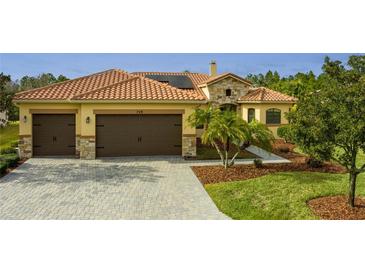 Two-story house with a tile roof, two-car garage, and landscaped yard at 729 San Raphael St, Kissimmee, FL 34759