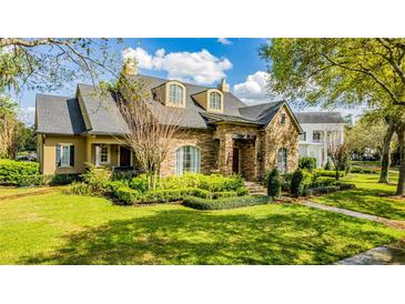 Two-story stone house with manicured lawn and landscaping at 222 Acadia Ter, Celebration, FL 34747