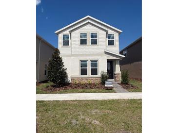 Charming two-story home features stone accents, neat landscaping, and an inviting covered entrance at 1227 Teal Creek Dr, Saint Cloud, FL 34771