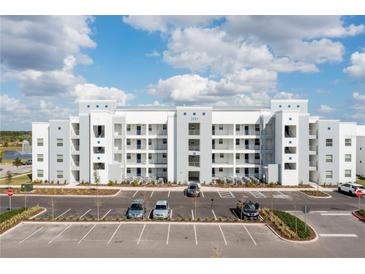 Modern multi-Gathering complex featuring a light gray and white exterior, balconies, and ample parking at 3191 Paradox Cir # 102, Kissimmee, FL 34746