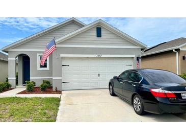 Two-story house with attached garage and landscaped front yard at 2657 Harmonia Hammock S Rd, Harmony, FL 34773