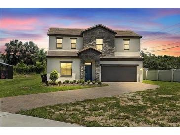 Two-story house with stone accents and a two-car garage at 233 Macaulay S Cv, Haines City, FL 33844