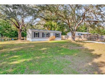 Charming single-story home featuring a well-maintained lawn and mature trees at 9100 Sw 32Nd Ct, Ocala, FL 34476