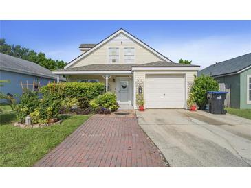 Charming yellow house with a brick driveway and well-manicured landscaping at 1452 Brookebridge Dr, Orlando, FL 32825