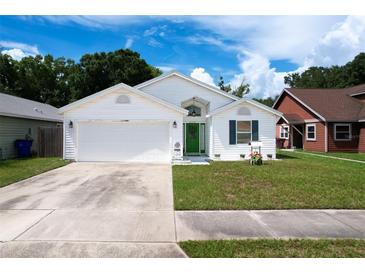 Charming single-story home featuring a well-maintained lawn, two-car garage, and bright green front door at 4316 Natchez Trace Dr, St Cloud, FL 34769