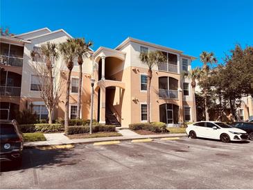 Condo building exterior featuring landscaping, stairs to upper floors, and multiple parking spaces at 3224 Dante Dr # 108, Orlando, FL 32835