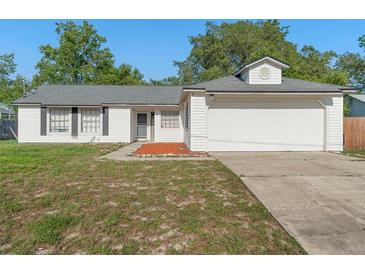 Charming single-story home with white siding, dark shutters, and a well-maintained front yard at 2495 Sedgefield Ave, Deltona, FL 32725