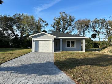 Charming single-story home with a well-manicured front yard and a gray brick driveway at 29 W 17Th St, Apopka, FL 32703