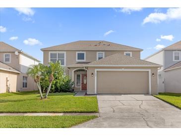 Charming two-story home with a well-manicured lawn and mature palm trees at 132 Spanish Bay Dr, Sanford, FL 32771