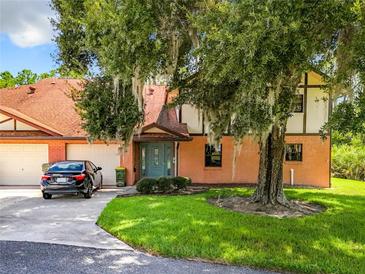 Brick townhouse with attached garage and lush landscaping at 100 E Oak Terrace Dr # G1, Leesburg, FL 34748