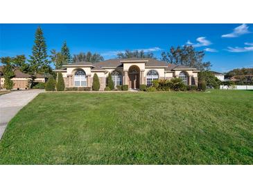 Single-story home exterior with manicured lawn and walkway at 13707 Calle De Ora Ct, Clermont, FL 34711