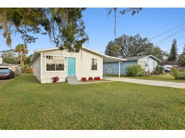Charming single-story home featuring a well-manicured lawn and a bright blue front door at 610 Walker St, Holly Hill, FL 32117