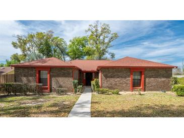 Charming single-story brick home with a well-manicured lawn and mature trees at 1546 Stormway Ct, Apopka, FL 32712