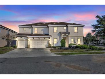 Two-story house with three-car garage, and manicured landscaping at 7001 Oakwood St, Davenport, FL 33837