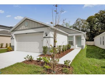 Charming single-story home featuring a two-car garage and a well-manicured lawn and landscaping at 8645 Caribbean Pine Way, Lakeland, FL 33809