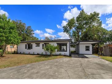 Charming single-story home featuring a well-manicured lawn, a covered carport, and a freshly painted exterior at 220 Lake Gene Dr, Longwood, FL 32779