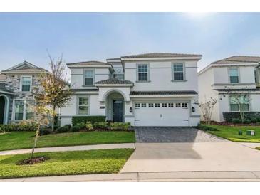 Charming two-story home featuring a clean white facade, manicured lawn, and a paved driveway leading to a spacious garage at 1548 Moon Valley Dr, Davenport, FL 33896