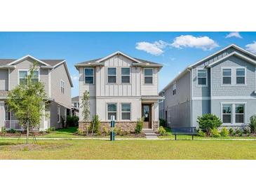 Charming two-story home featuring stone accents, landscaping, and a well-maintained green lawn at 1211 Teal Creek Dr, St Cloud, FL 34771