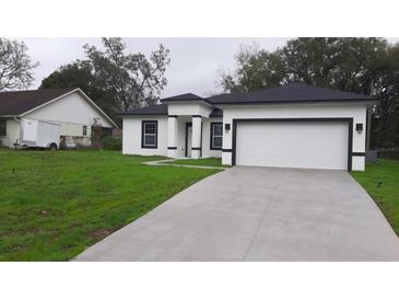 Charming single-Gathering home with fresh exterior paint, long driveway, and a two-car garage at 12793 Sw 43Rd Cir, Ocala, FL 34473