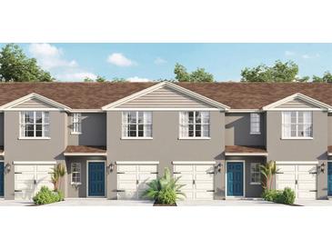 Charming townhomes boast a modern facade with blue doors, white garages, and neatly manicured landscaping at 559 Zinfandel Dr, Holly Hill, FL 32117