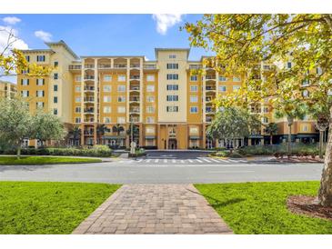 Luxury condo building with multiple floors, balconies, and ample parking at 8112 Poinciana Blvd # 1305, Orlando, FL 32821