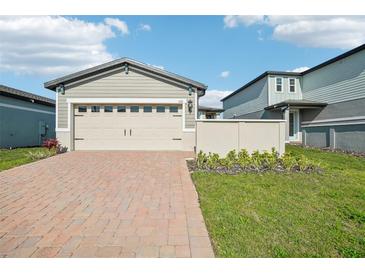 Charming home featuring a spacious two-car garage with a brick paver driveway and manicured lawn at 510 Kennedy Dr, Lake Alfred, FL 33850