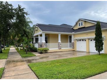 Charming single-story home with a welcoming porch, well-maintained lawn, and two-car garage at 9238 Kensington Row Ct, Orlando, FL 32827