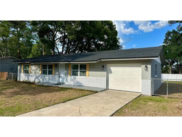 Charming single-story home featuring a brick facade, a well-manicured lawn, and an attached garage at 1801 James St, South Daytona, FL 32119