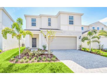 Charming two-story home featuring a beautifully landscaped front yard and a two-car garage at 1697 Kona Ln, Davenport, FL 33897