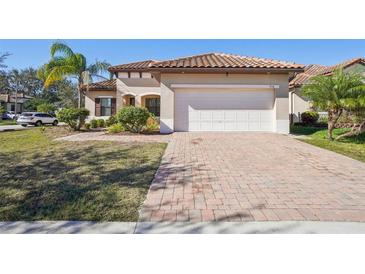 Single-story home with tile roof, paver driveway, and landscaped yard at 310 Villa Sorrento Cir, Haines City, FL 33844