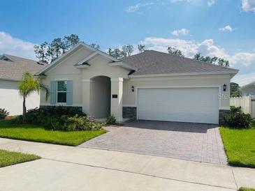Single-story home with a two-car garage and landscaped lawn at 737 Trillium Ct, Debary, FL 32713