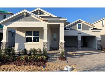 Charming single-Gathering home with a two-car garage, stone accents, and a well-manicured front yard at 16875 Muskgrass Dr, Winter Garden, FL 34787