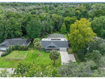 Beautiful aerial view of property with mature trees and screened-in pool at 668 Coral Way, Winter Springs, FL 32708