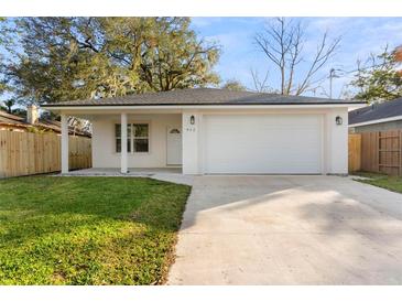 Newly constructed home with a white exterior, attached garage, and well-manicured lawn at 912 W 5Th St, Lakeland, FL 33805