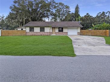 Charming single-Gathering home featuring a brick facade, well-manicured lawn and a long driveway at 4814 Lake Shore Dr, St Cloud, FL 34772