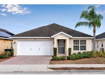 One-story home with white garage door, gray front door, and landscaped yard at 258 Vizcay Way, Davenport, FL 33837