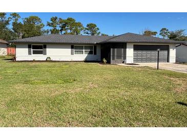 Charming single-story home with a well-manicured lawn and a two-car garage at 260 S Fairbairn Dr, Deltona, FL 32725