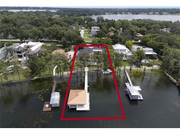 Waterfront estate with multiple docks and boat houses along the shore of a pristine lake at 904 Main St, Windermere, FL 34786