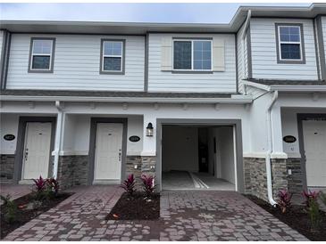 Modern two-story townhome with attached garage and brick accents at 5072 Rain Shadow Dr, Saint Cloud, FL 34772