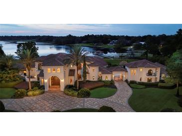 Stunning waterfront estate with a beautifully landscaped yard, circular driveway and Mediterranean-style architecture at 1965 Lake Markham Preserve Trl, Sanford, FL 32771