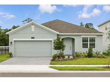 Charming one-story home featuring a neutral color scheme, brick driveway, and well-manicured lawn at 2585 Cavanaugh Dr, Orlando, FL 32817