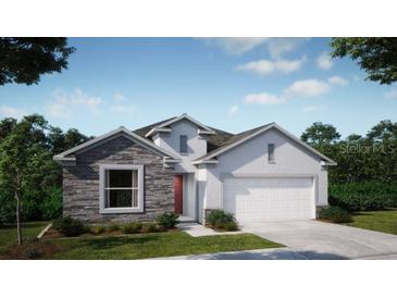 Charming single-story home featuring stone accents, neutral colors, a two-car garage, and professionally landscaped yard at 1685 Andover Ridge Dr, Deland, FL 32720