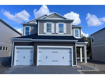 Two-story home with a two-car garage and a gray exterior, featuring white trim and a well-manicured lawn at 1181 Basalt Ln, Sanford, FL 32771