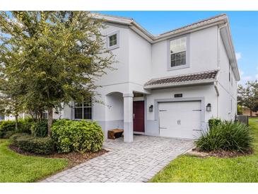 Charming two-story home featuring a one car garage, brick walkway, and well-maintained landscaping at 1638 Moon Valley Dr, Davenport, FL 33896