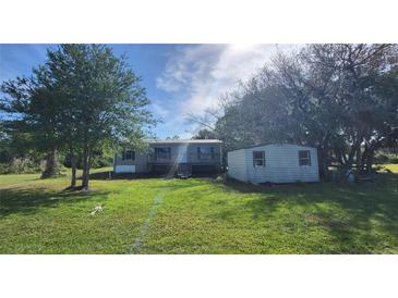 Charming home with a spacious front yard and shed surrounded by mature trees, offering a serene setting at 2661 Waccassa St, Geneva, FL 32732