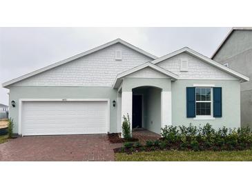 Charming single-Gathering home featuring a brick driveway, attached garage, and well-maintained landscaping at 14771 Erice Ave, Clermont, FL 34714