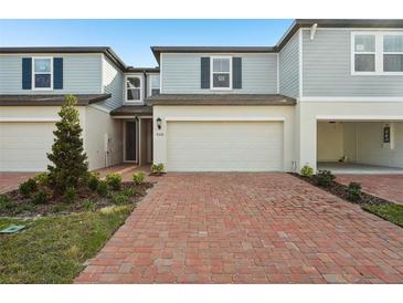 Charming townhome featuring a brick-paved driveway and two-car garage at 4320 Ranch House Rd, Saint Cloud, FL 34772